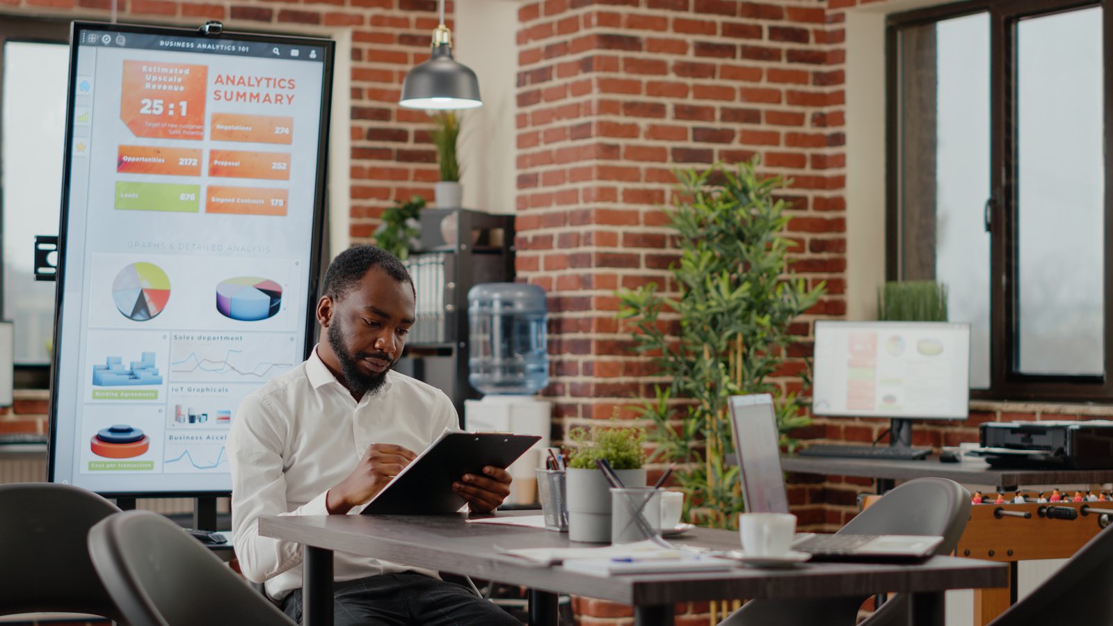 African american man greeting team of coworkers in startup office